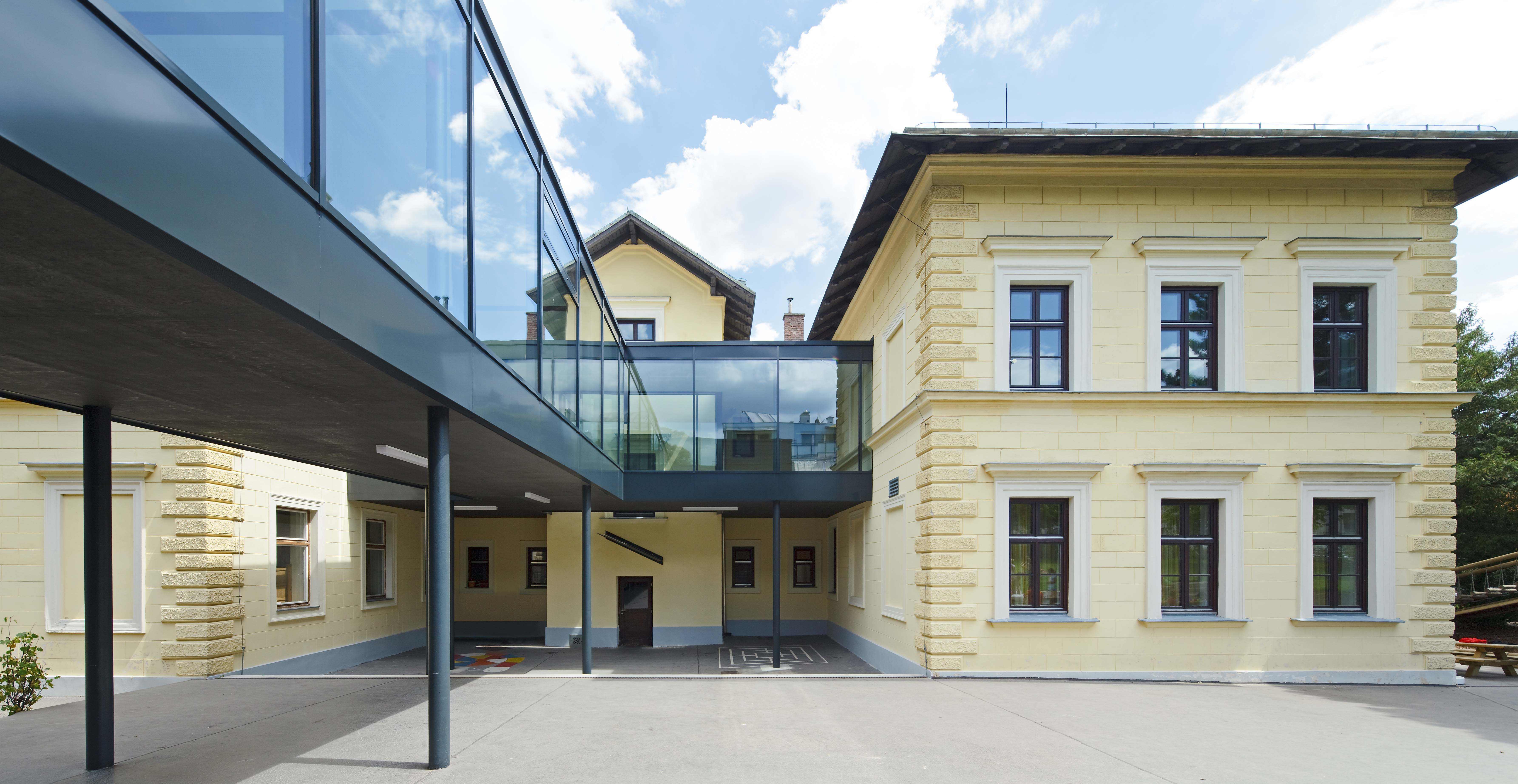 Blick auf das historische Schulgebäude und den verglasten Verbindungsgang zum neuen Bauteil der Schulerweiterung